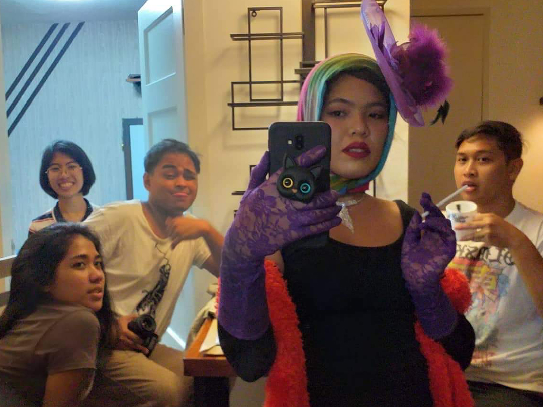 Anj Estrella dressed as chic Italian lady with crew members posing in front of mirror