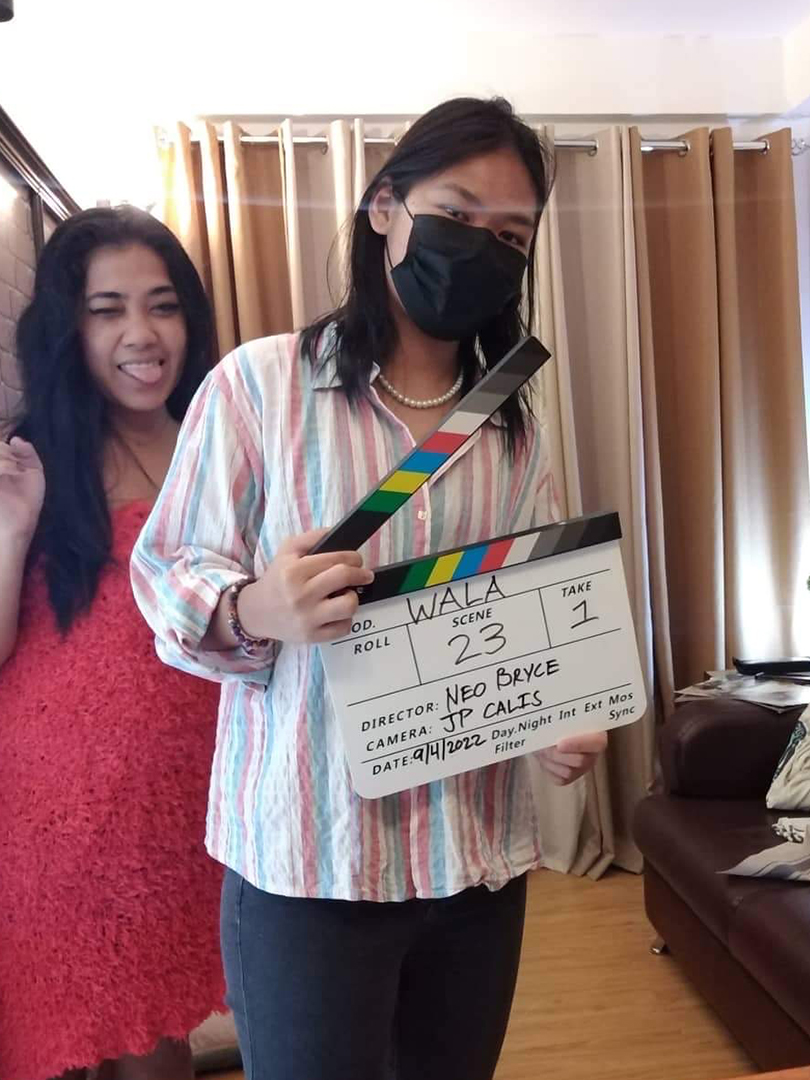 Maf Braceros and Gezelle Dacillo posing for camera with clapperboard